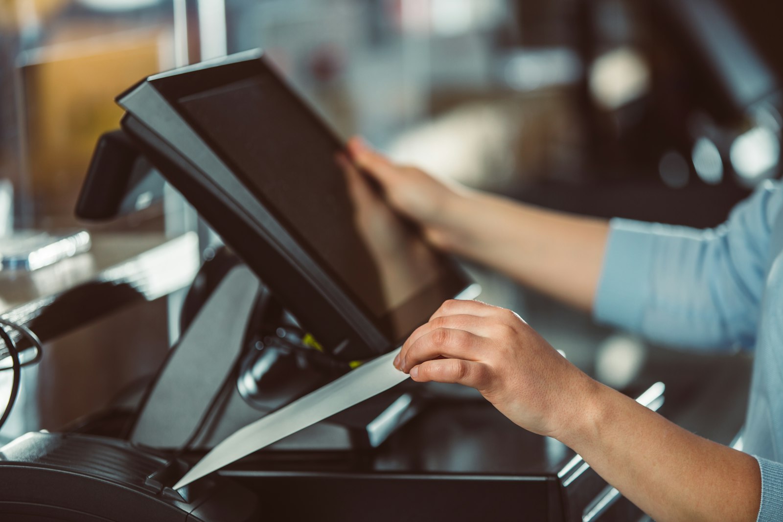 Foto ilustrativa de un empleado operando una terminal punto de venta, representando el login del operador